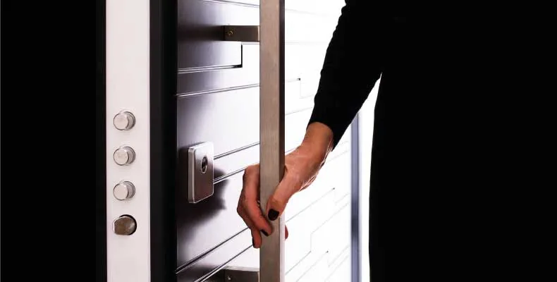 porta blindata Alias bianca aperta, con i catenacci del telaio e il defender in vista